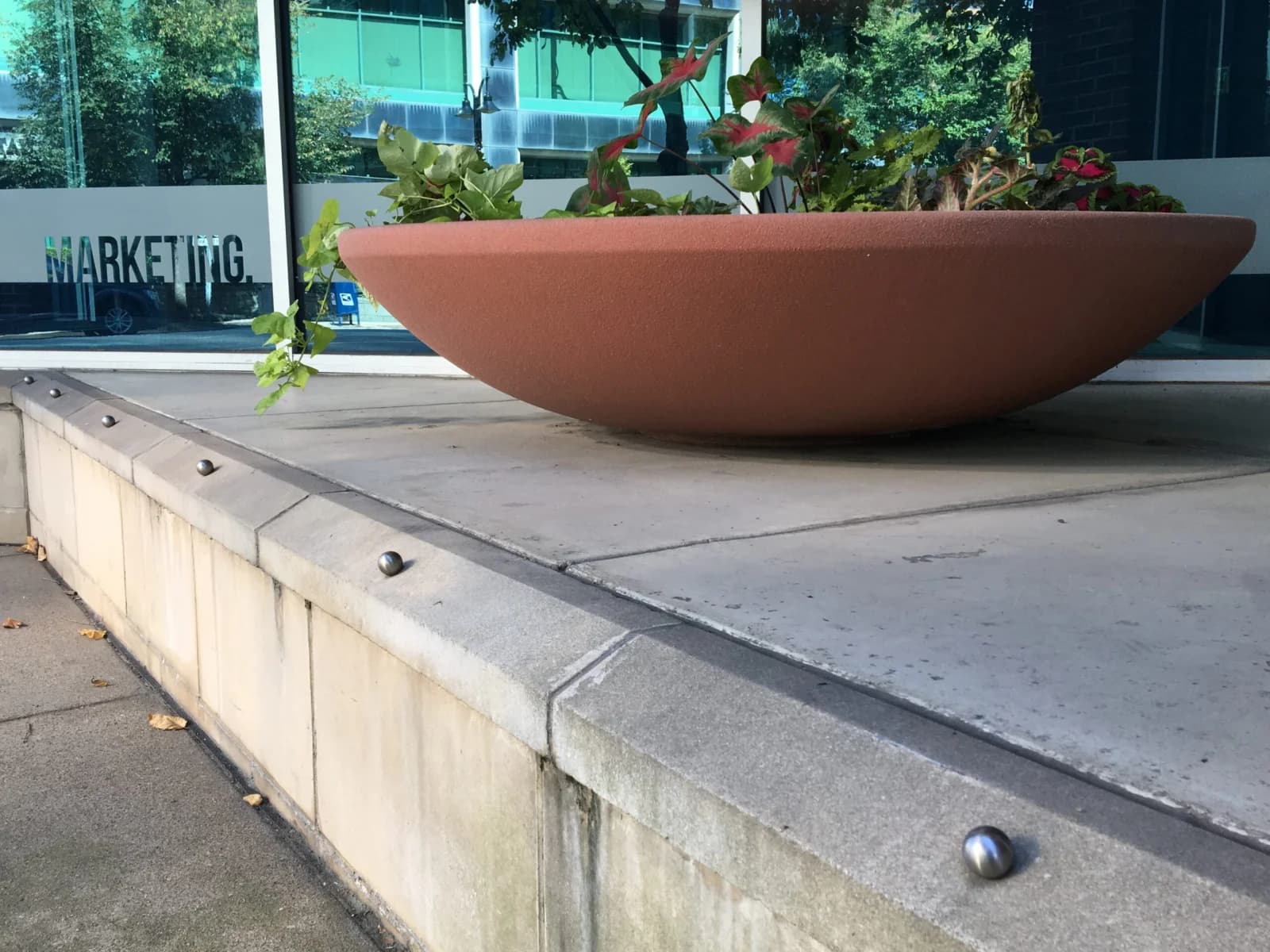 University campus handrail with stainless saddle skate-stop clamps along a granite staircase