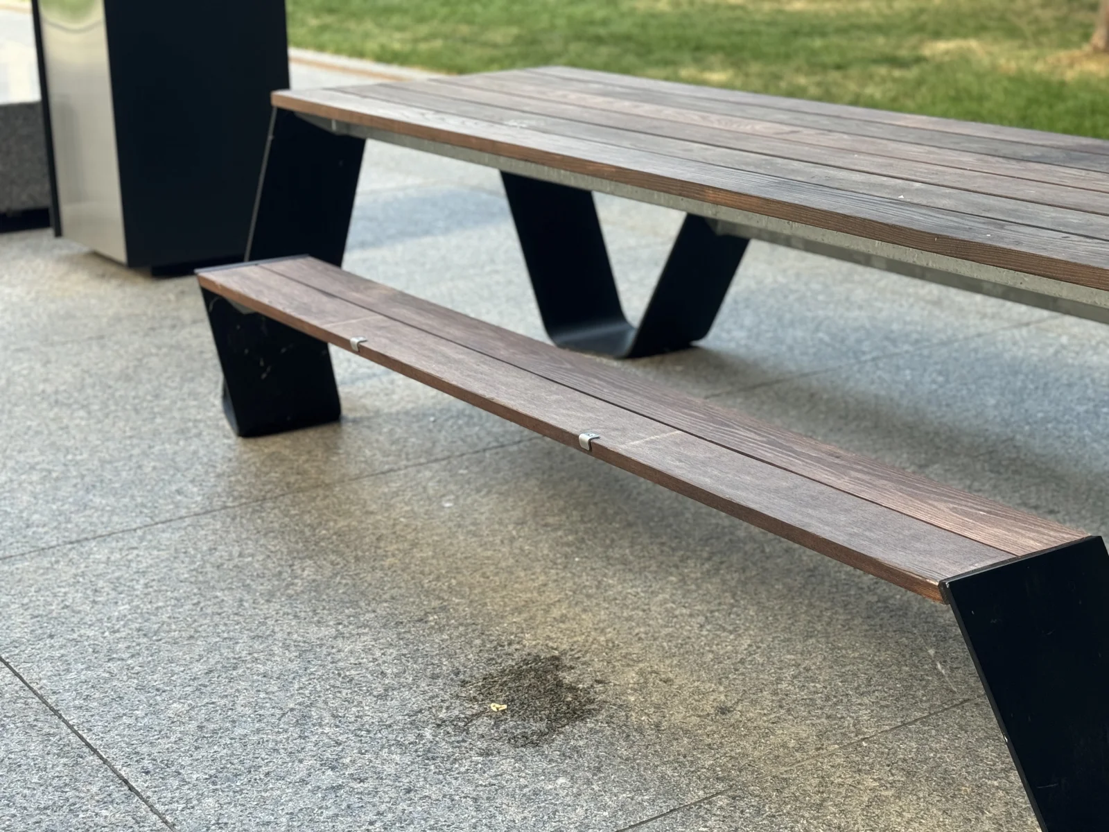 Skateboard deterrent studs spaced along a wood-slat park bench with metal frame in a Canadian municipal park